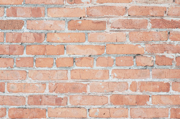 Brick wall. Old brick. Peeling paint. Light pink and gray. Orange.