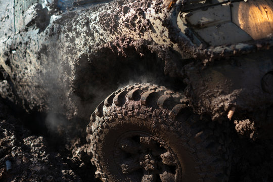 4x4 off-roading. Wheel close up in a countryside landscape with a muddy road. Offroad. Closeup photo of car wheel. 4x4 travel trekking. Off road sport truck.