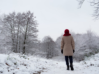 Woman walk in winter snow forest.