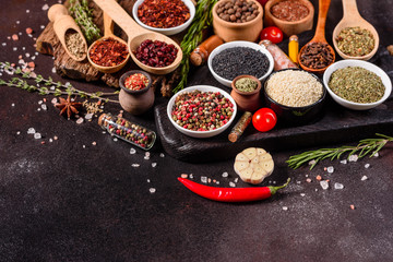 Spices and herbs over black stone background. Top view with free space for menu or recipes