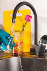 water purification specialist tap water pours into a glass flask.