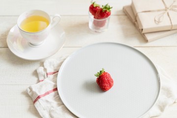 Health products. Green tea and strawberries. Food photo in high key. Tea set and gifts.