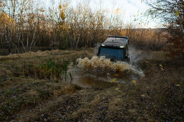 4x4 concept. SUV or offroader on mud road. Large rocks on the road extreme travel adventure in nature. Track on mud. Outdoors adventures. Safari. Off-road Ride on the of-road car. © Volodymyr