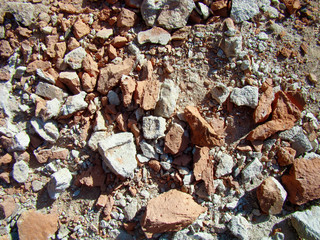 Broken red brick and white concrete. Shade from the bright sun. Texture, cracks, chips.