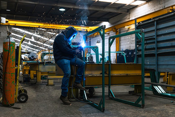 Man welding in a workshop full of sparks