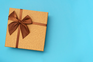 Brown gift box with brown  ribbon isolated on blue background