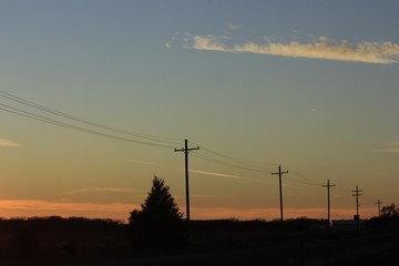 Fototapeta na wymiar Sunset with Power Lines,Tree's, and a colorful sky in Kansas,.