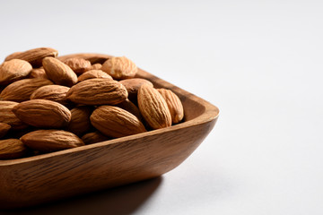 Close up almonds in a wooden bowl with copy space