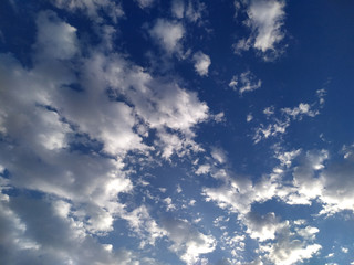 white shining clouds flying in blue sky