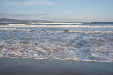 Daylight, summer day, light breeze on the seashore, incident waves on the shore.