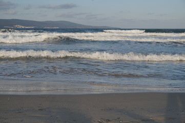 Daylight, summer day, light breeze on the seashore, incident waves on the shore.