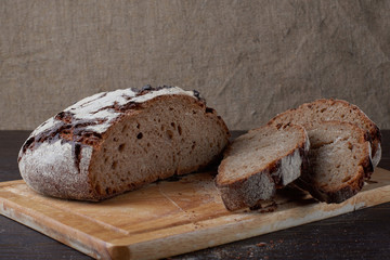 Fresh bread on the table close-up in flour placer. Fresh bread on the kitchen table. Healthy eating and the traditional concept of the bakery. Rustic style