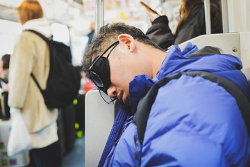  Asian men sleep on the train in Japan.