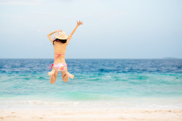 海でジャンプするビキニを着た女性