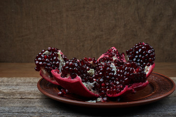Ripe pomegranate fruit on an old black wooden vintage background.
