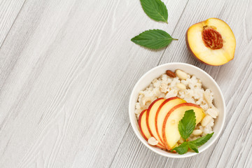 Sorghum salad with nuts and fresh peach on wooden background.