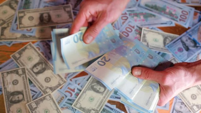 A businessman is counting 20 euro banknotes