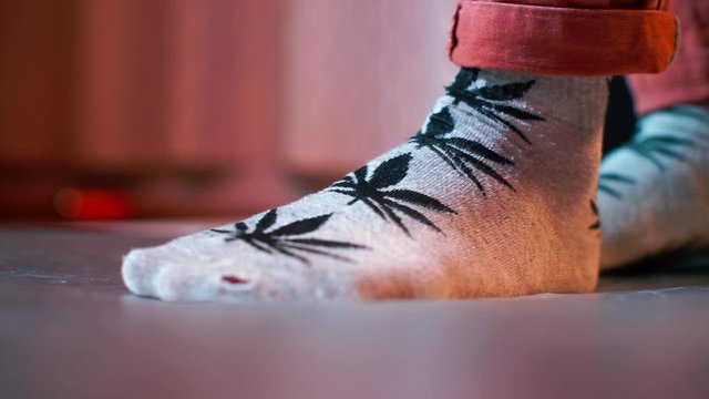 Dance foot movements in socks with cannabis designs. 