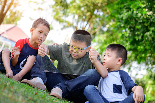 Asian children studying future programs at the park,Modern high tech concepts