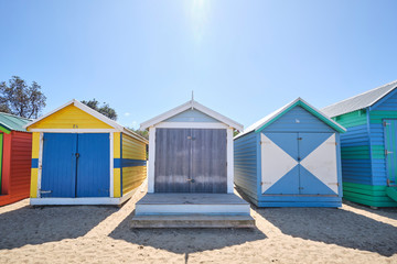 Obraz na płótnie Canvas Brighton Beach huts/boxes on a blue sky sunny day with bright colours and textures