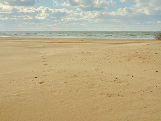 Fototapeta na wymiar Empty sands beach, blue sky and clouds. Close up. Copy space
