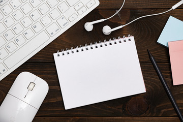 Office desk table with notepad, white keyboard and supplies. Top view with copy space