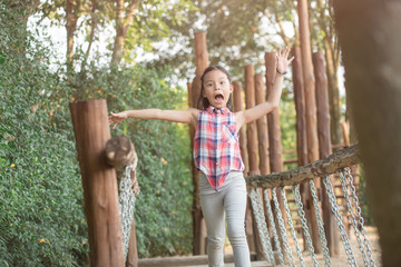 Obraz premium happy little asian girl child having fun to playing in the playground in summer time with smile and laughing healthy, funny smiling face adorable lovely female kid. happy vacation lifestyle concept.