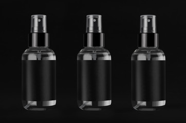 Luxury transparent spray dispenser bottles for cosmetics product collection with black label in a row on dark black background, mock up for design.