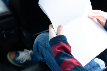 Closeup, Hands of teenage student hold worksheets, read out loud, review materials, memorize lessons with concentration, pressure and stress in back seat of car, last minute exam preparation.