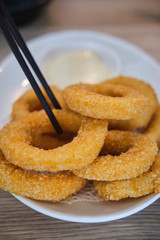 Calamari rings in restaurant with tartare sauce on the side