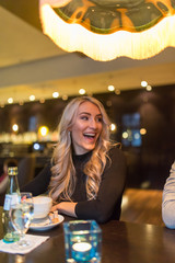 Frau lacht in einem Restaurant am Tisch