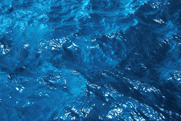 Texture blue sea water with sunny reflections. Classic blue background