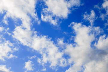 Light fluffy white cumulus clouds on a blue sky on a clear sunny day
