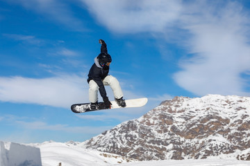 Snowboarder jumps in snow park