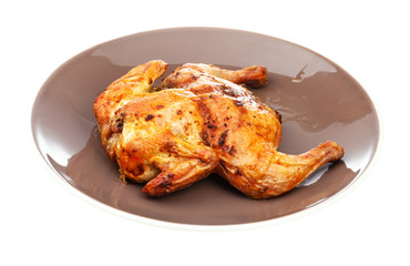 roasted whole flattened chicken on brown plate