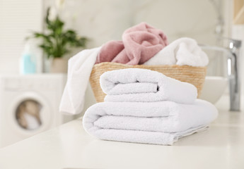 Clean towels on countertop in laundry room - obrazy, fototapety, plakaty
