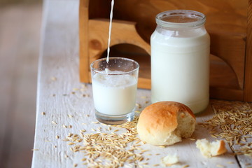 Milk in a jar and rolls on the table