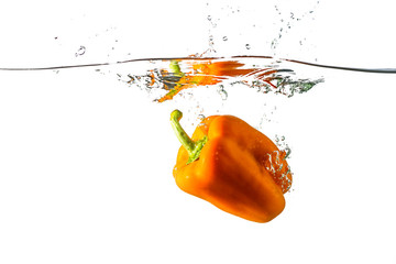 Bulgarian orange pepper thrown into water on a white background