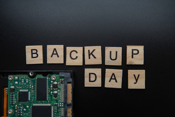 Words in English Backup day. Copy space for text. HDD hard drive. hard disk on black dark...