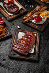 Roasted Honey Glazed Rack of Pork Ribs. Octoberfest party dinner. Festive table with delicious food on black boards. Octoberfest party dinn