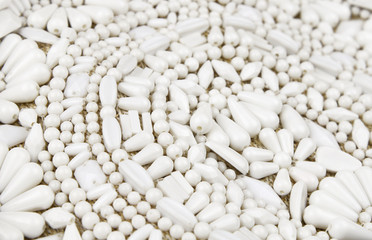 Beige canvas embroidered with white beads for background. Selective focus.