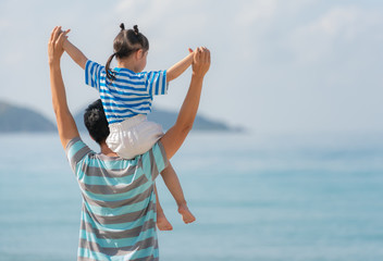 Asian father and daughter on the beach.