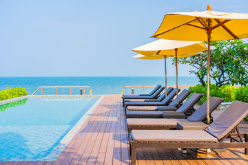 Beautiful empty chair umbrella around outdoor swimming pool in hotel resort for travel
