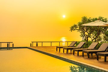 Beautiful sunrise around with umbrella and chair outdoor swimming pool