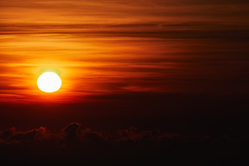 Sunrise / sunset over the clouds and horizon in golden colors.