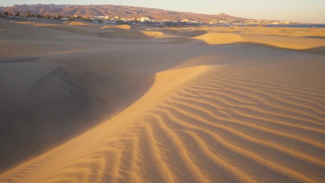 sandy golden dunes of Maspalomas at sunrise, famous tourist destination, walking in desert on sunny morning