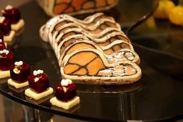 Salmon fillet with squid in.in the glaze, garnished with berry jelly on bread toast, .laid out on a black glass stand