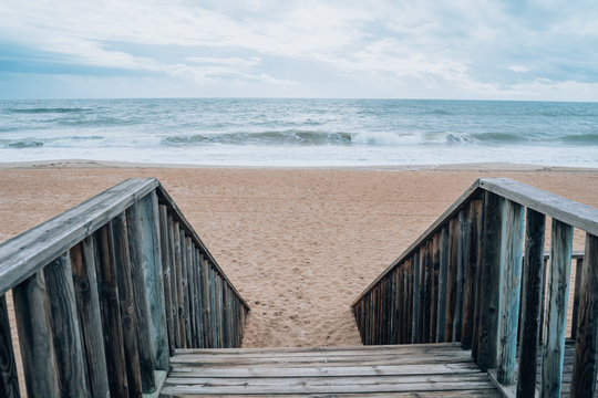 Stairs leading down to the sandy beach at Islantilla Spain during a cloudy, cold winter day