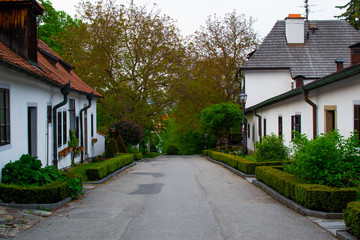 Fototapeta na wymiar Sidewalk between white typical houses in the Castle Gardens in Cesky Krumlov, Czech Republic