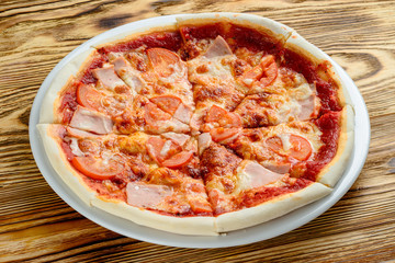 small pizza with tomatoes for children on a wooden background